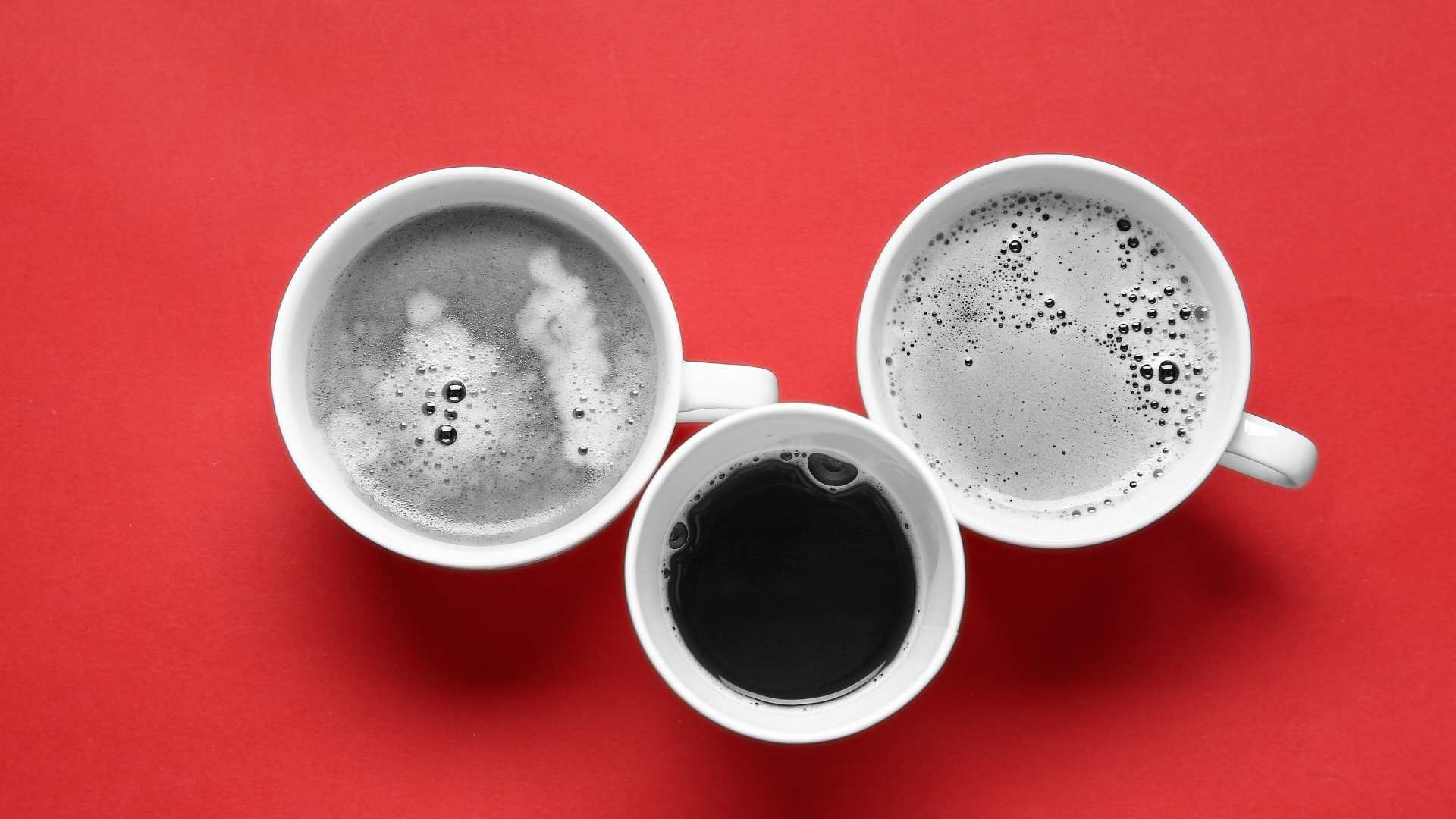 Trois tasses de café sur fond rouge qui incarnent la collaboration étroite avec une agence web pour la création d'un site WordPress