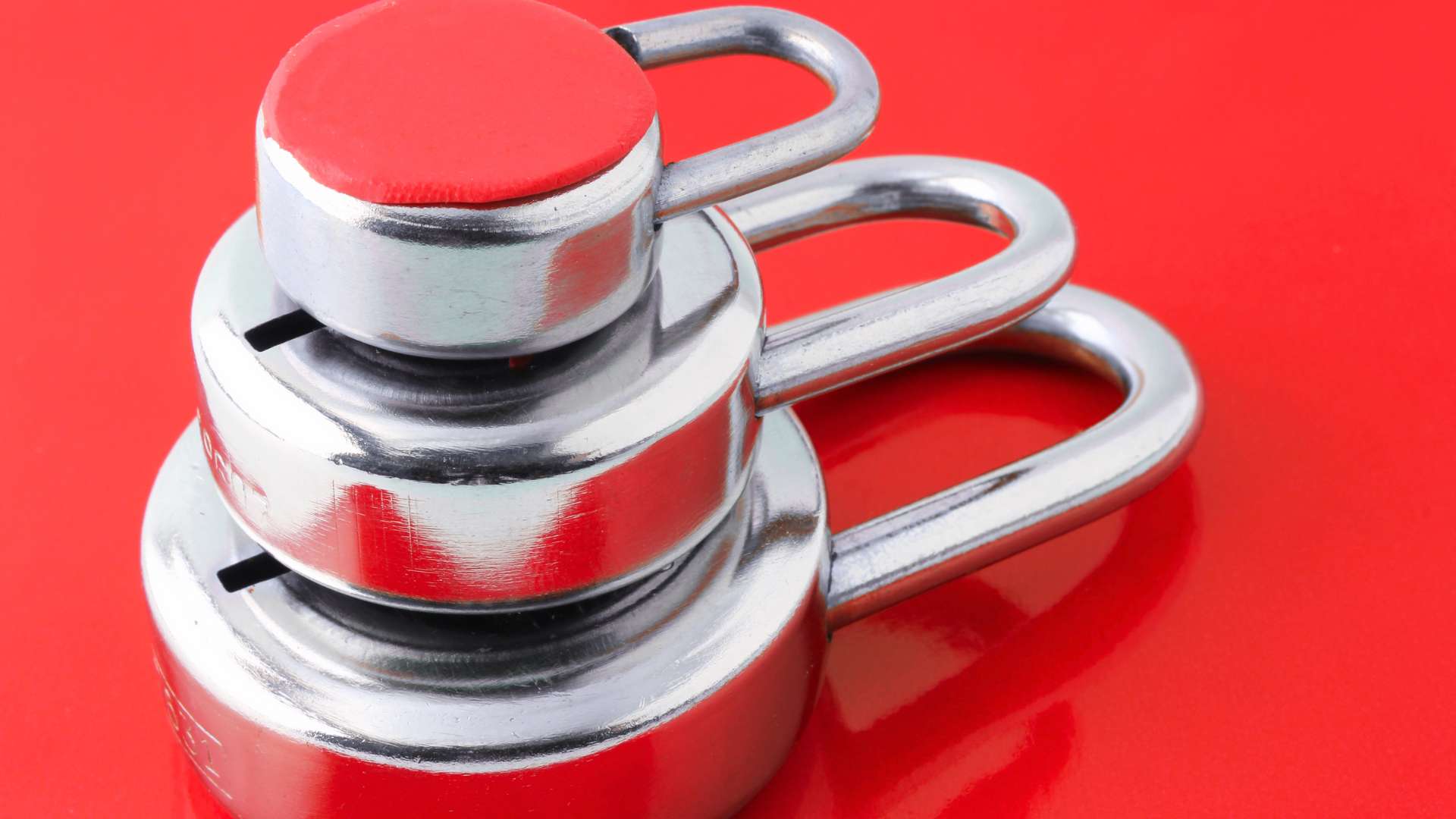 Verrous métalliques empilés sur un fond rouge, qui incarnent la sécurité robuste nécessaire pour la protection des données sur un site WordPress