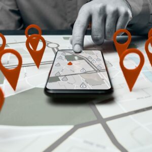 Carte interactive avec des repères géographiques rouges et un smartphone qui illustrent une stratégie de référencement local